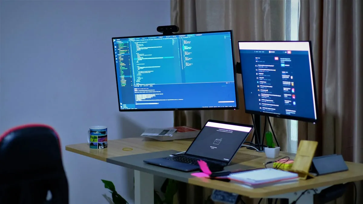 Person setting up trading automation on computer screens